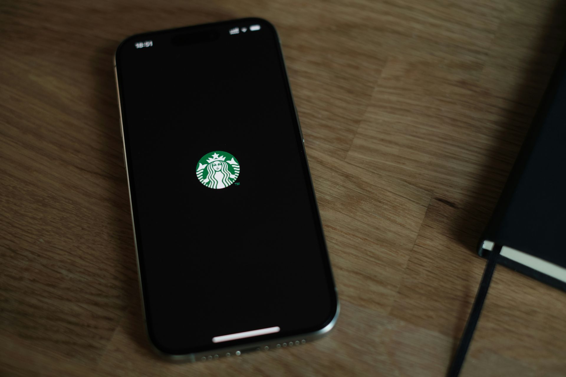 A starbucks logo is on the screen of a cell phone