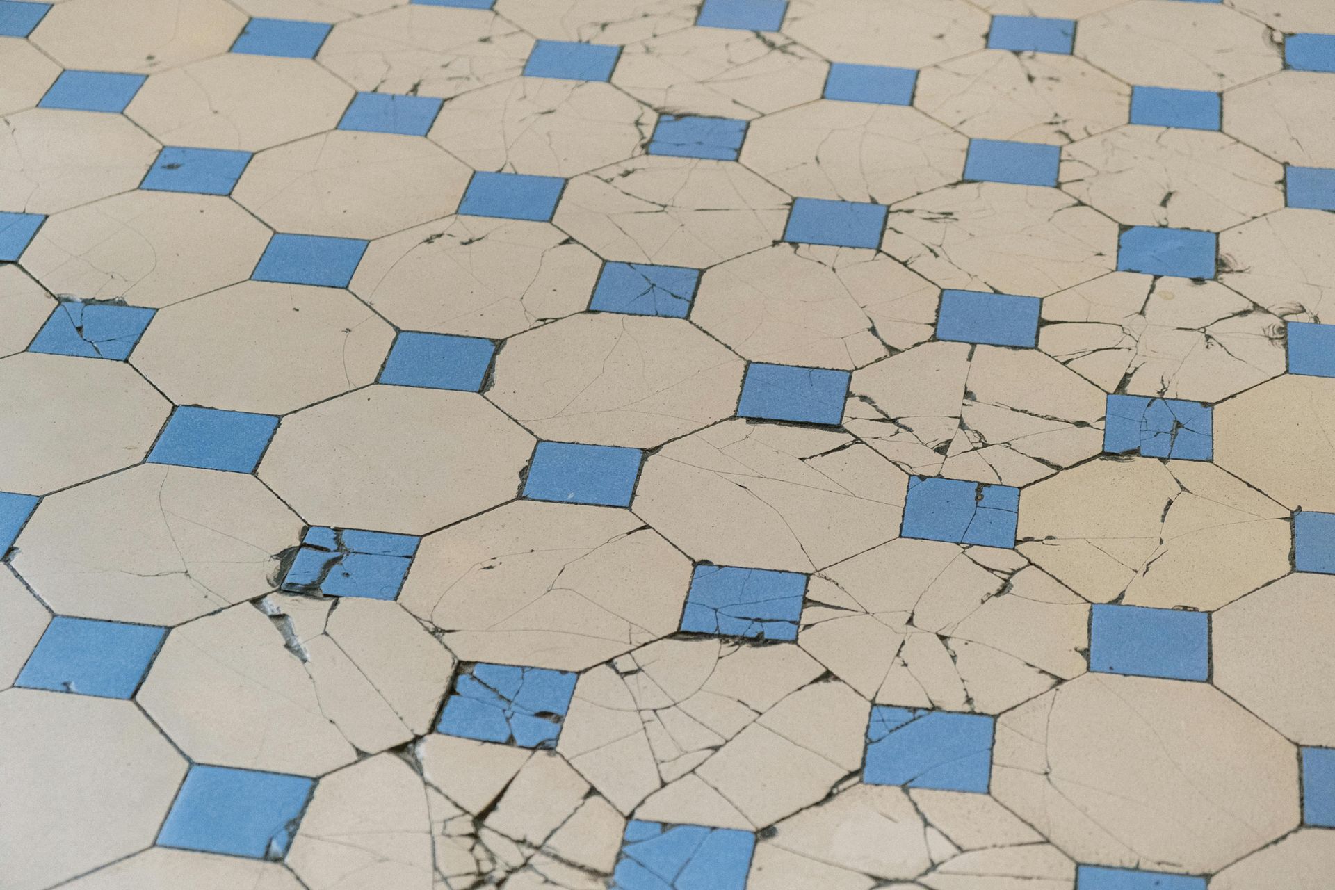 Damaged, patterned floor with white octagons and blue squares.