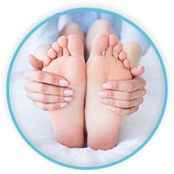 a woman is holding her feet in her hands while sitting on a bed
