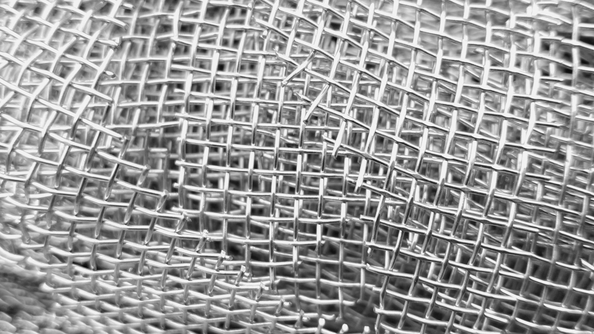 Close-up of industrial stainless steel woven wire mesh texture background.