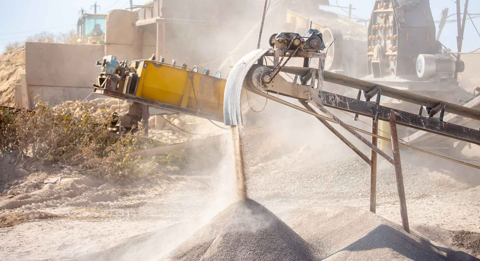 Vibrating screen stone crusher in operation. Vibrating screen stone crusher in operation.