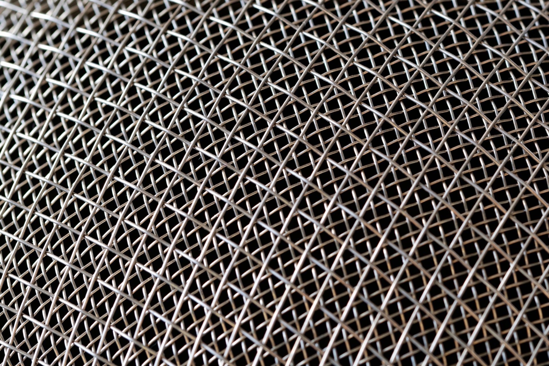 Metallic lattice with interlocking diagonal mesh in geometric pattern.