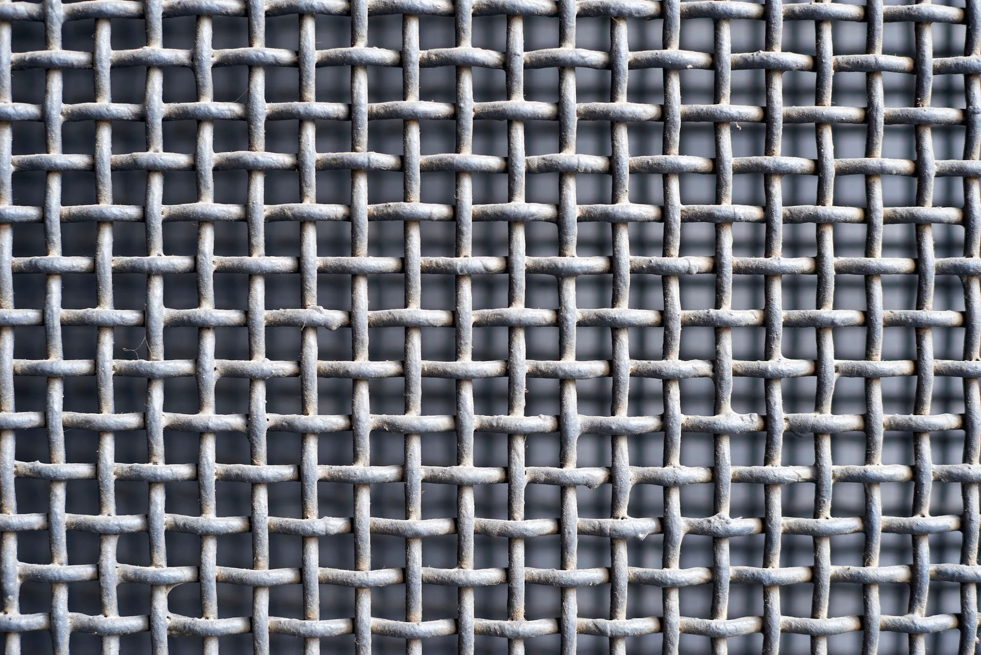 Woven wire cloth supplier displaying an interwoven metal wires forming a grid pattern.