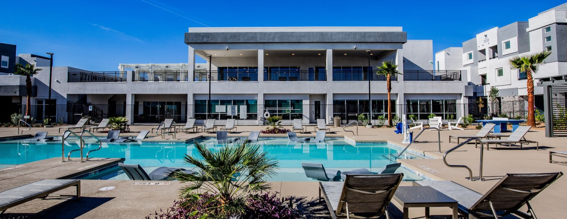 A woman wearing a straw hat is laying next to a pool.