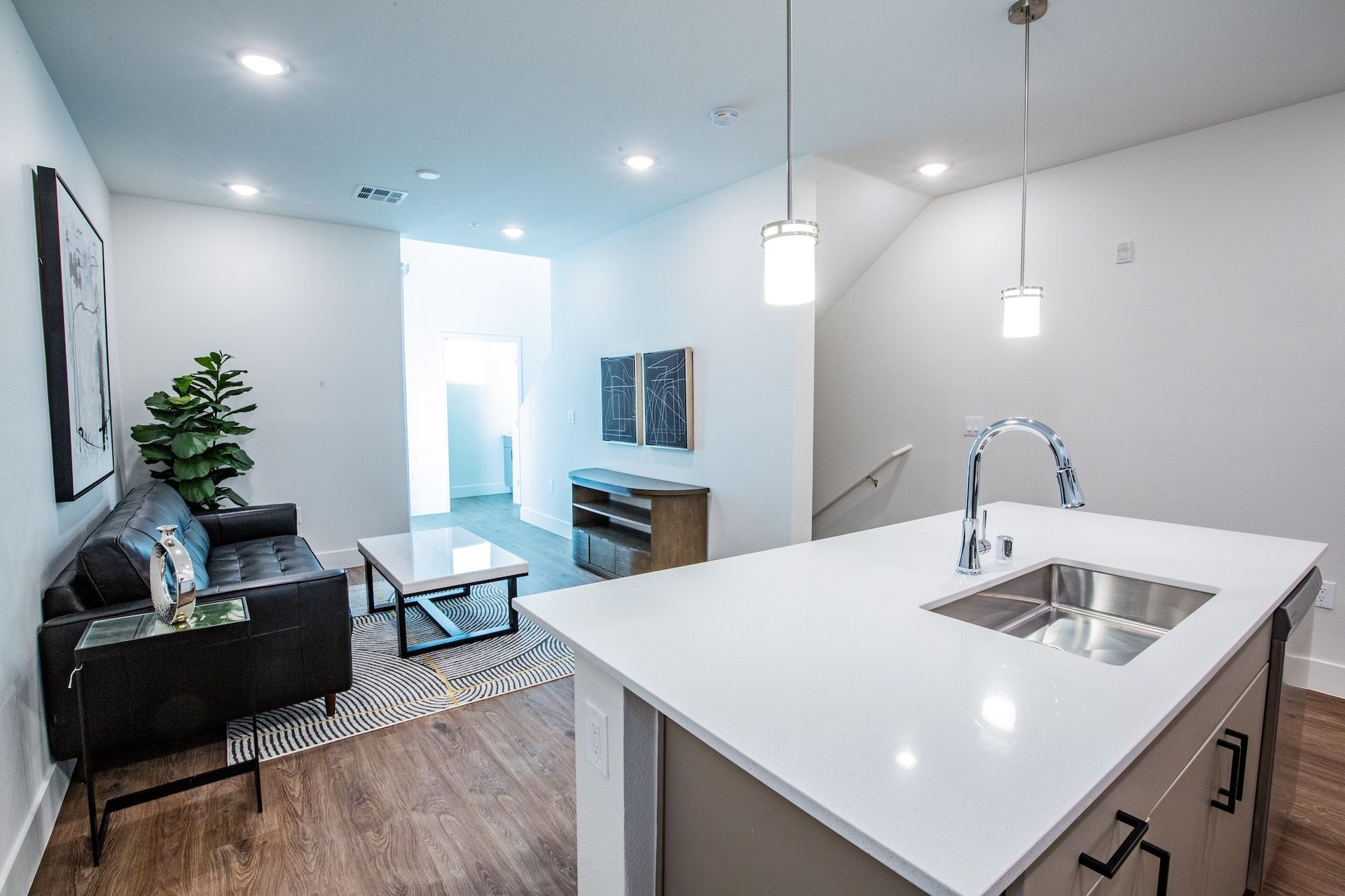 Modern apartment interior with kitchen island and living area.