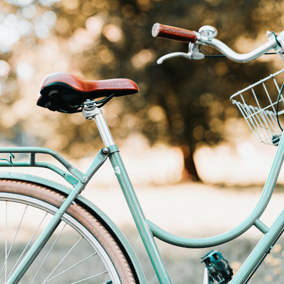 A green bicycle with a basket on the front