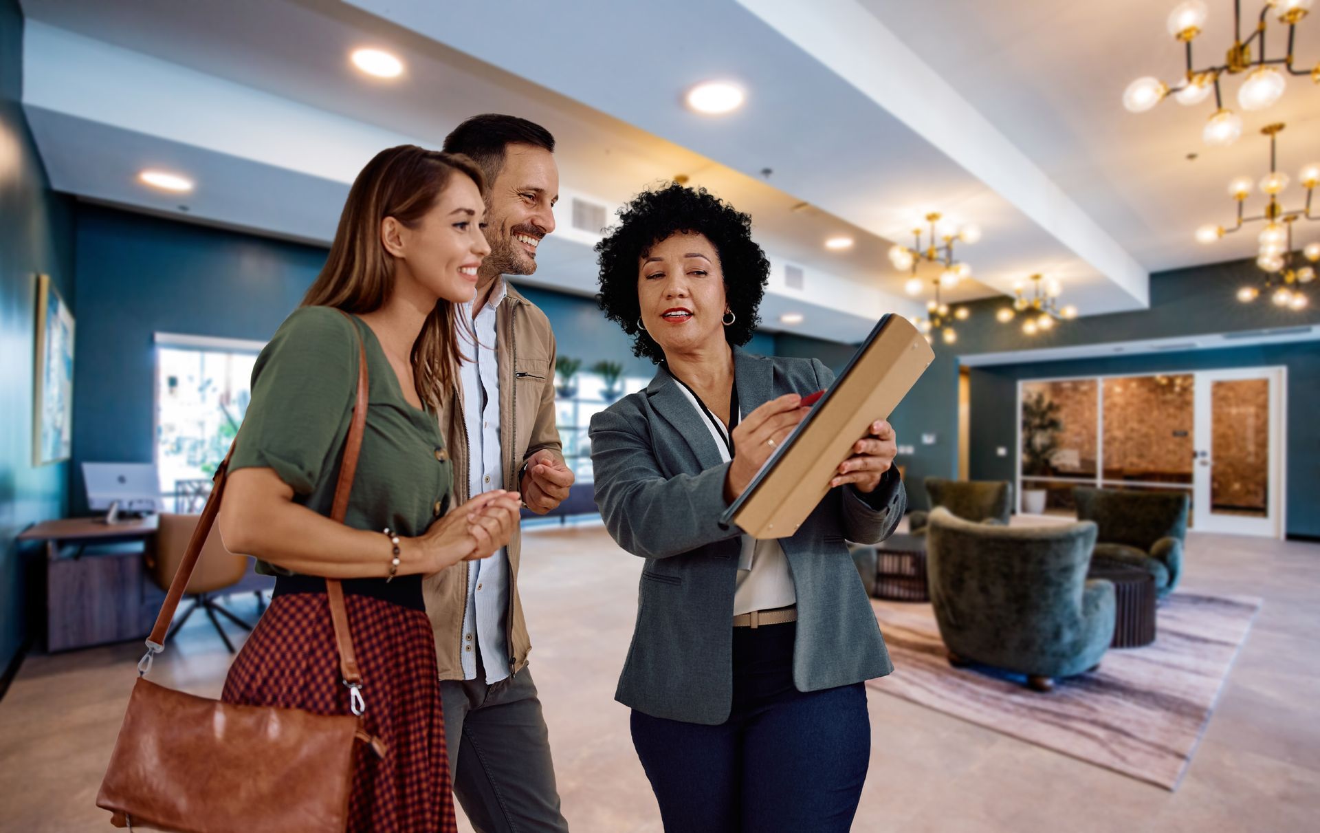 A man and a woman are looking at a book in a hotel lobby.