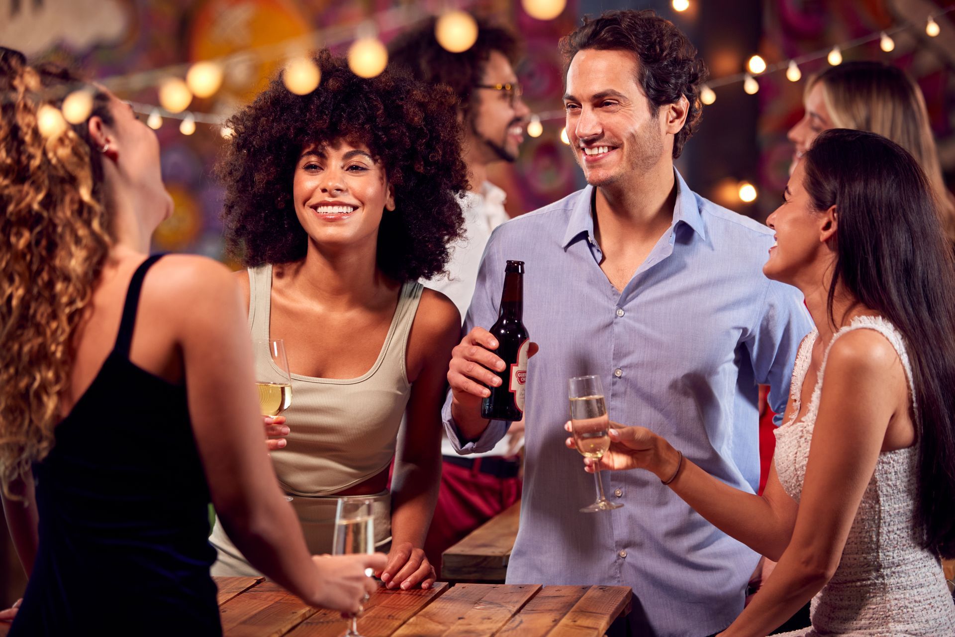 A group of people are sitting at a table drinking wine and beer.
