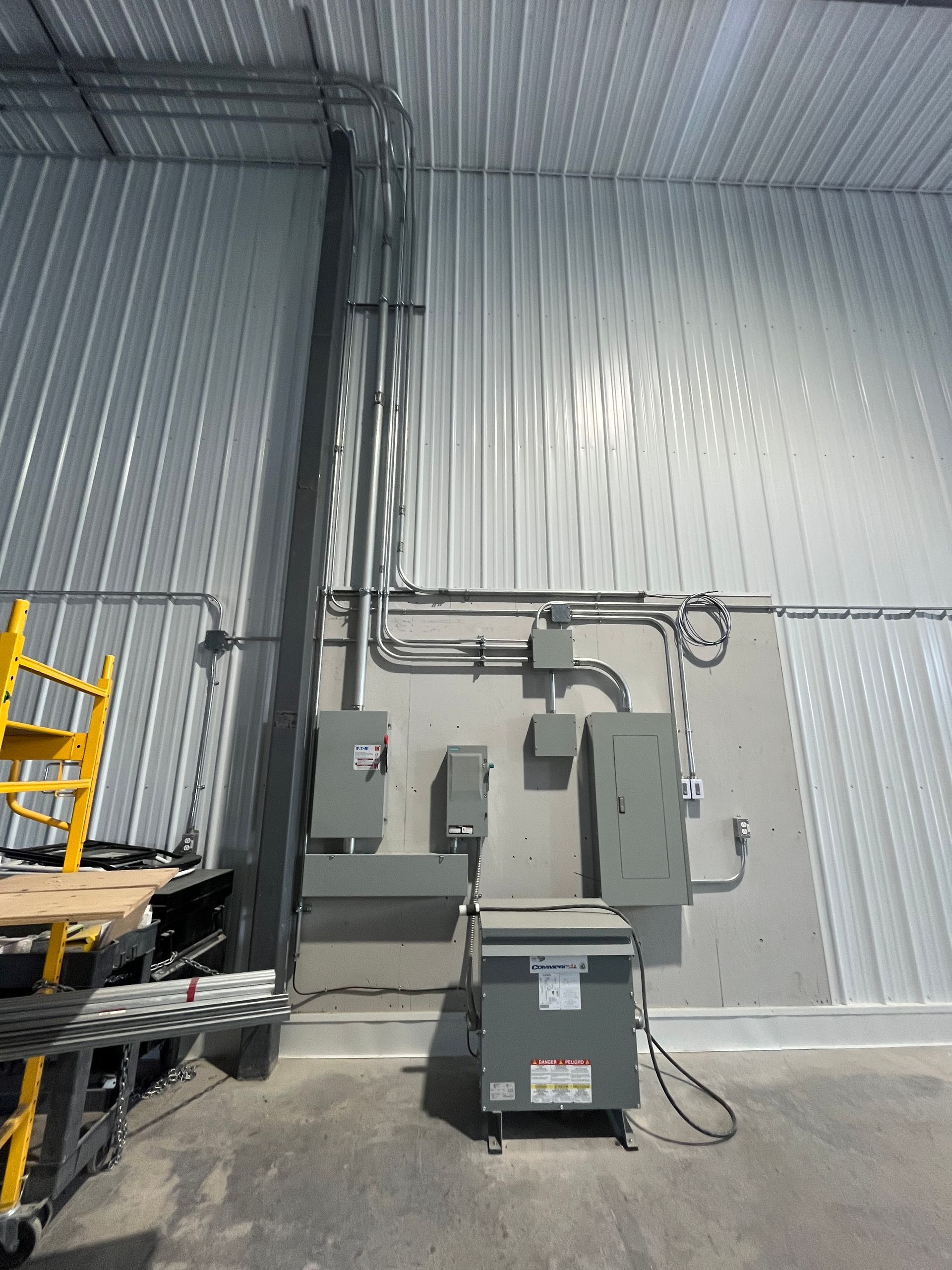 Un entrepôt avec beaucoup d'équipements électriques sur le mur.