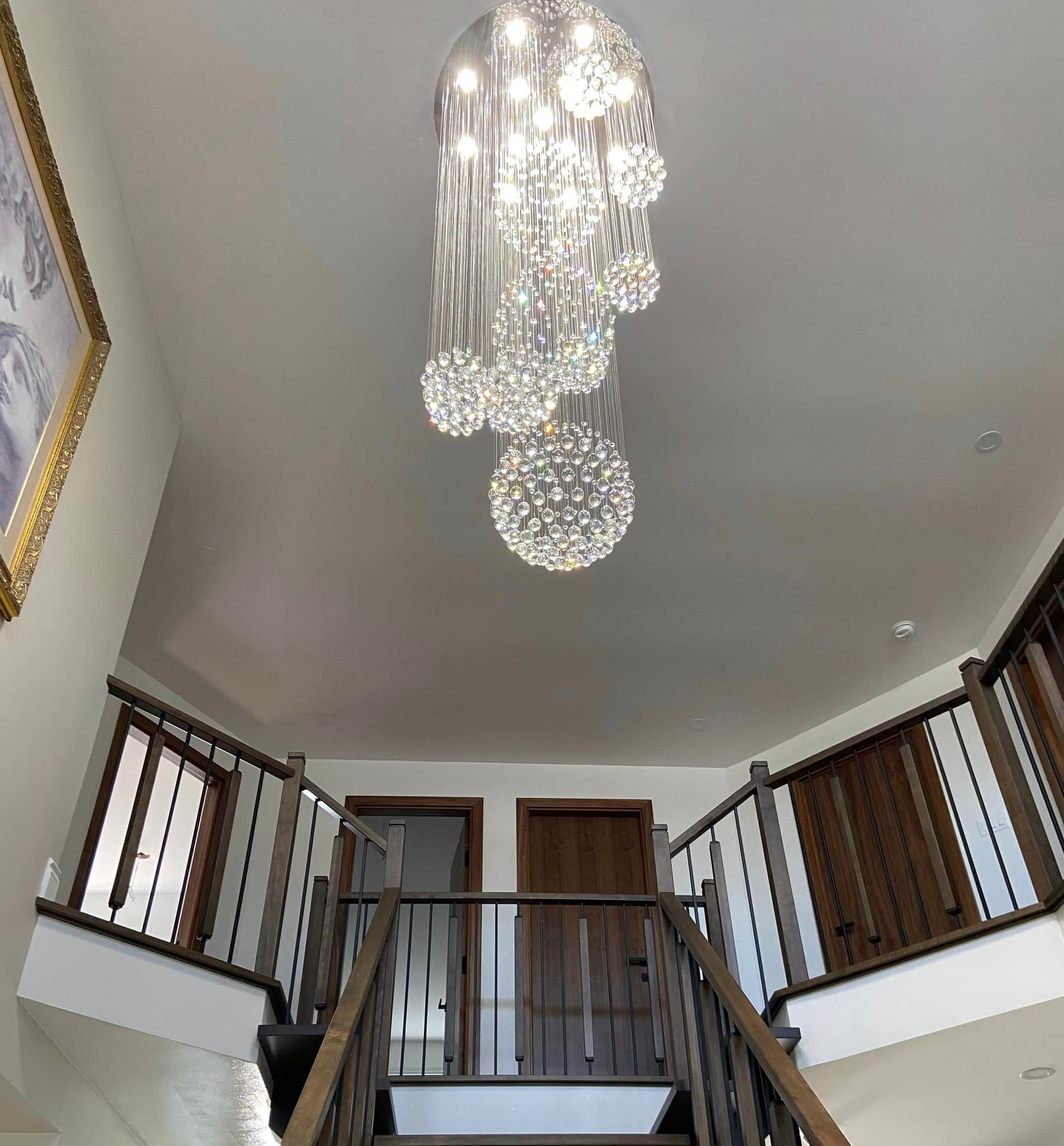 Un escalier avec un lustre suspendu au plafond