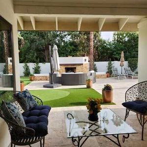 A patio with a couch , chairs , and a glass coffee table.