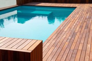 A swimming pool with a wooden deck surrounding it