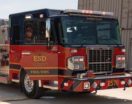 A red and white fire truck is parked in front of a building