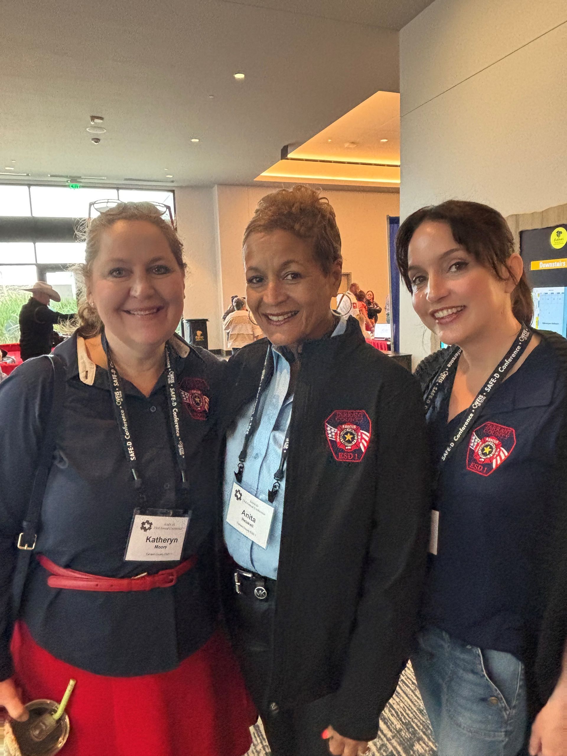 Three women posing for a picture at a conference.