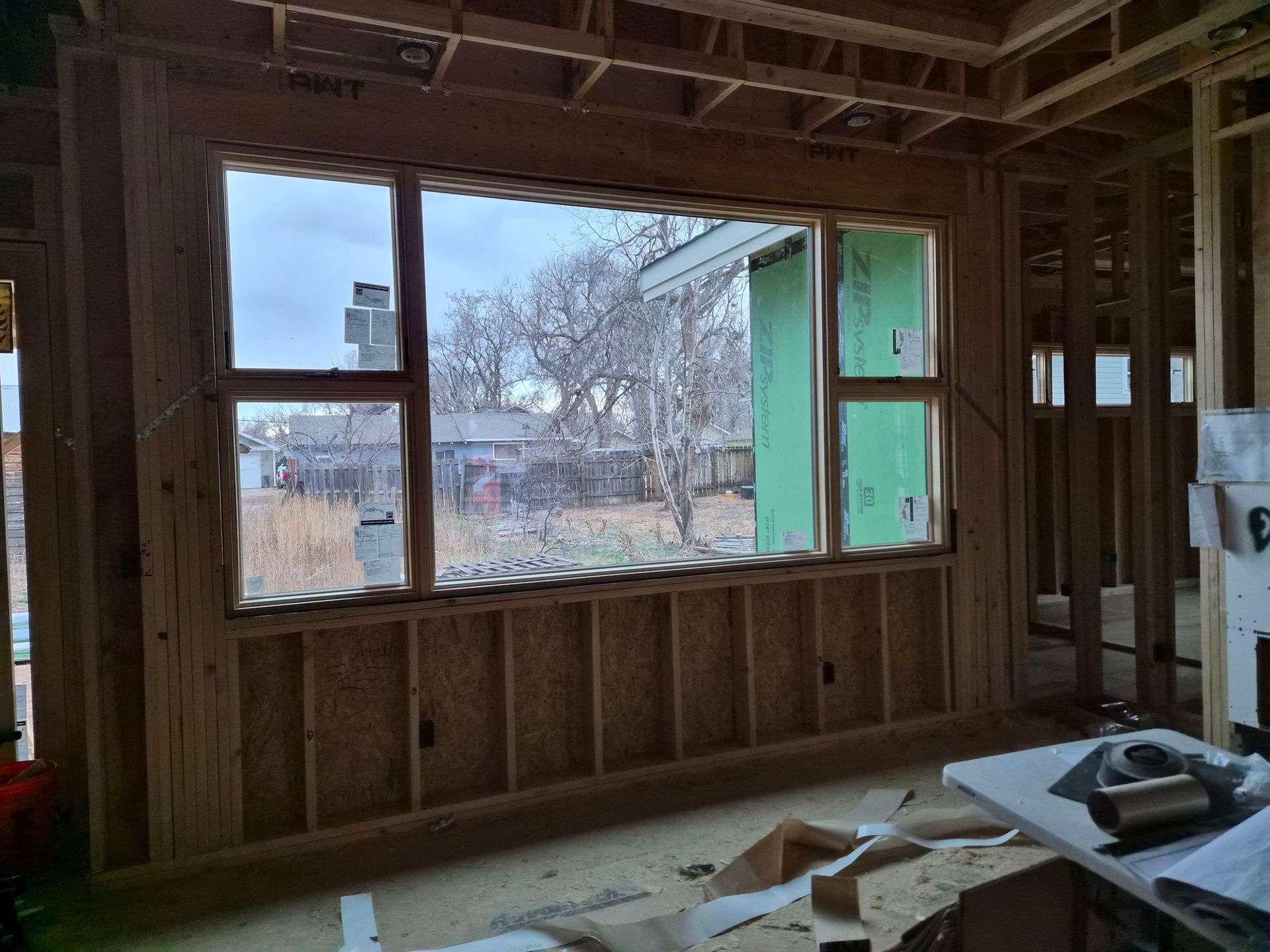 A wooden-framed window installed in an interior wall during the construction of a house.