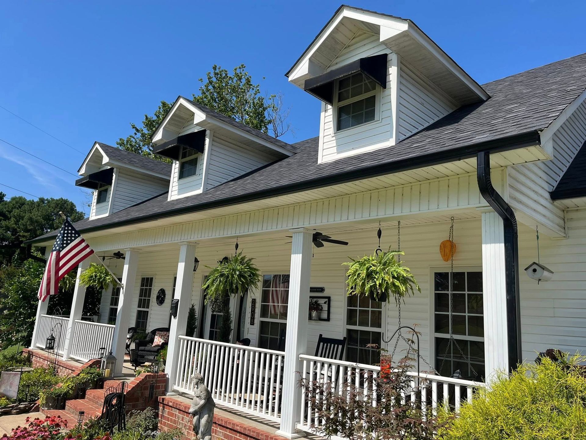 two story home with dark roof and gutters