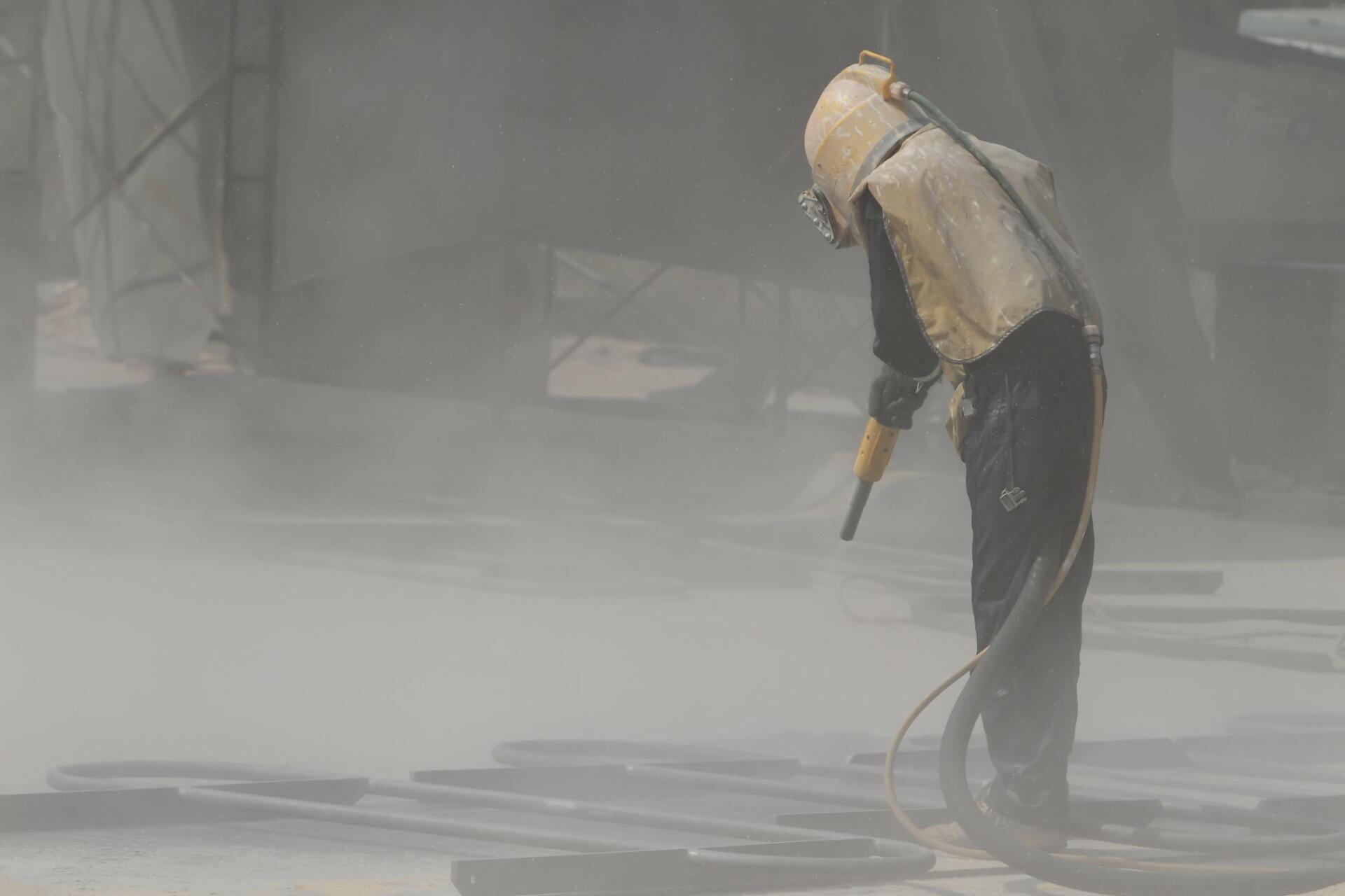 man using a sandblaster