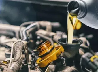 Despejando óleo de motor amarelo em um motor através de um funil, close-up da manutenção de um carro.