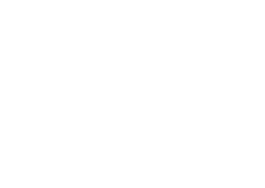 A diverse group of people sits in a circle on stools, engaged in a discussion in a bright, modern office space.