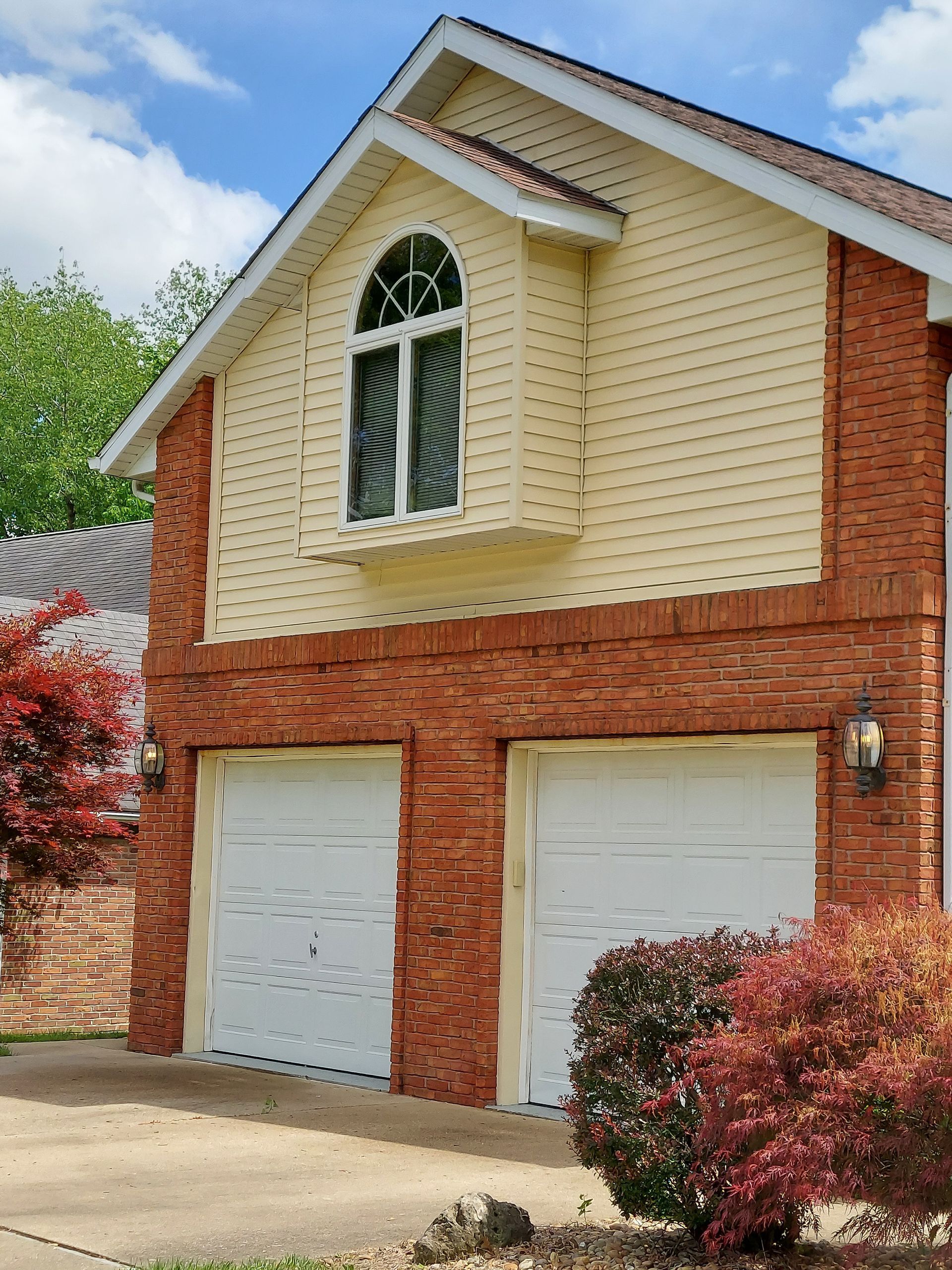 Professional soft wash house washing services for a yellow vinyl siding home in Belleville, IL.