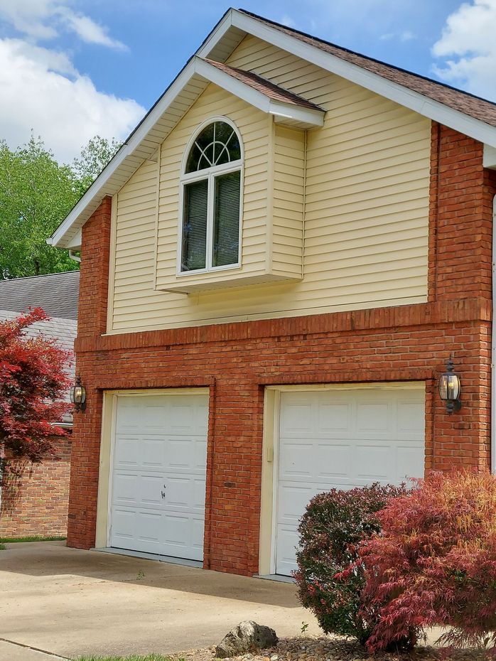 Professional soft wash house washing services for a yellow vinyl siding home in Belleville, IL.