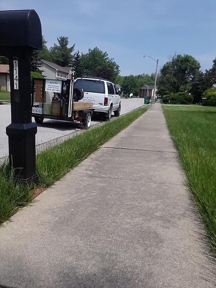 Dirty Sidewalk with SprytNa Exterior Cleaning's truck and pressure washing trailer