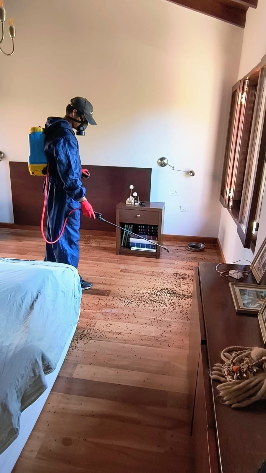 Un hombre está rociando una habitación con un rociador.