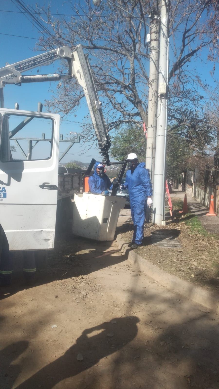 Un hombre está de pie junto a un camión con una grúa acoplada a él.