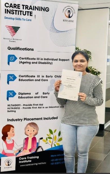 Young Black woman with dark hair and a black shirt, looking at the camera. She is against a peach-colored wall.