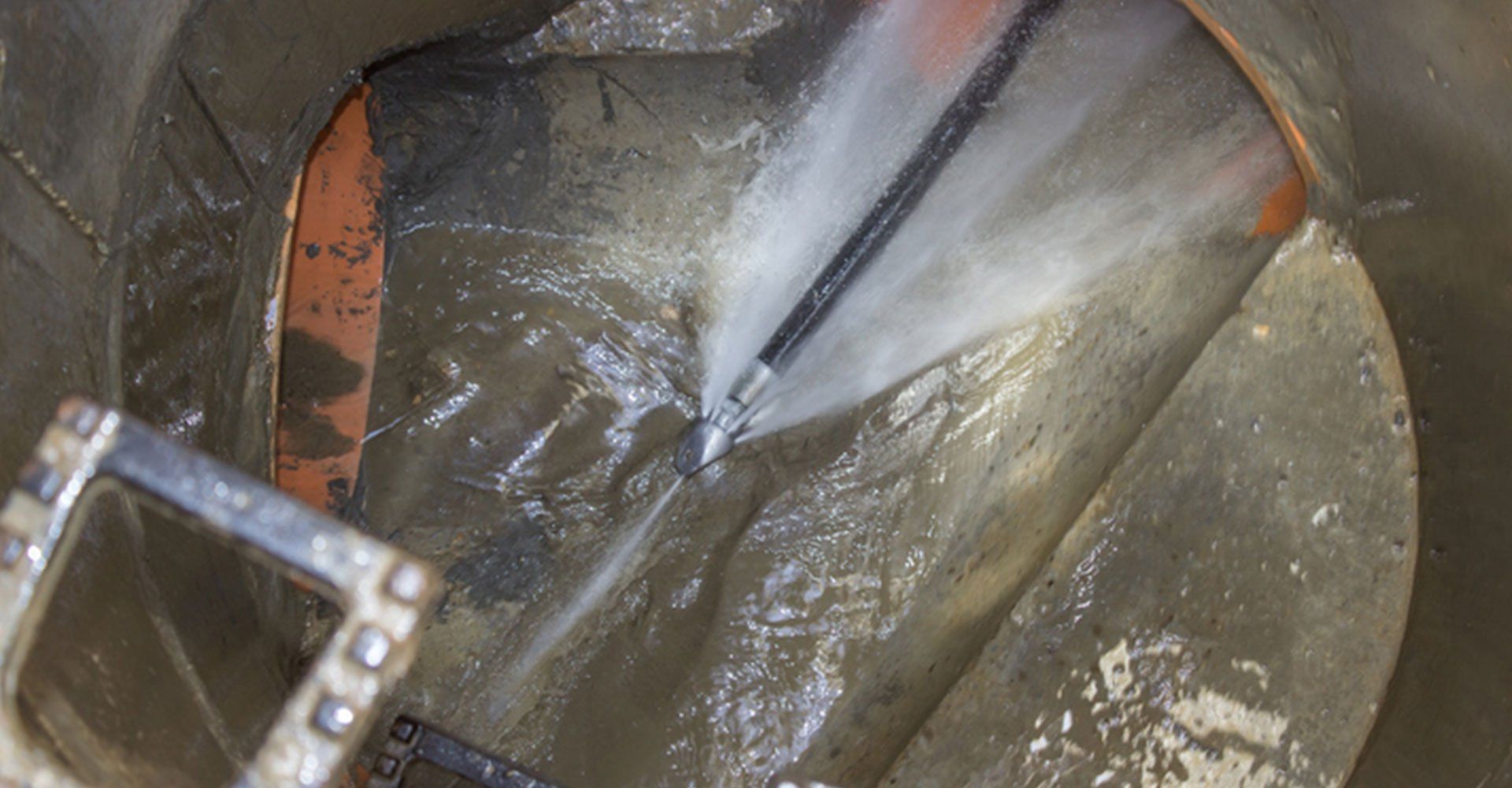 High-pressure water jet cleaning a pipe, spraying water.