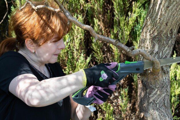 woman cuts off thick branches