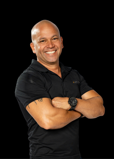 Smiling bald man in a black shirt with arms crossed on a black background