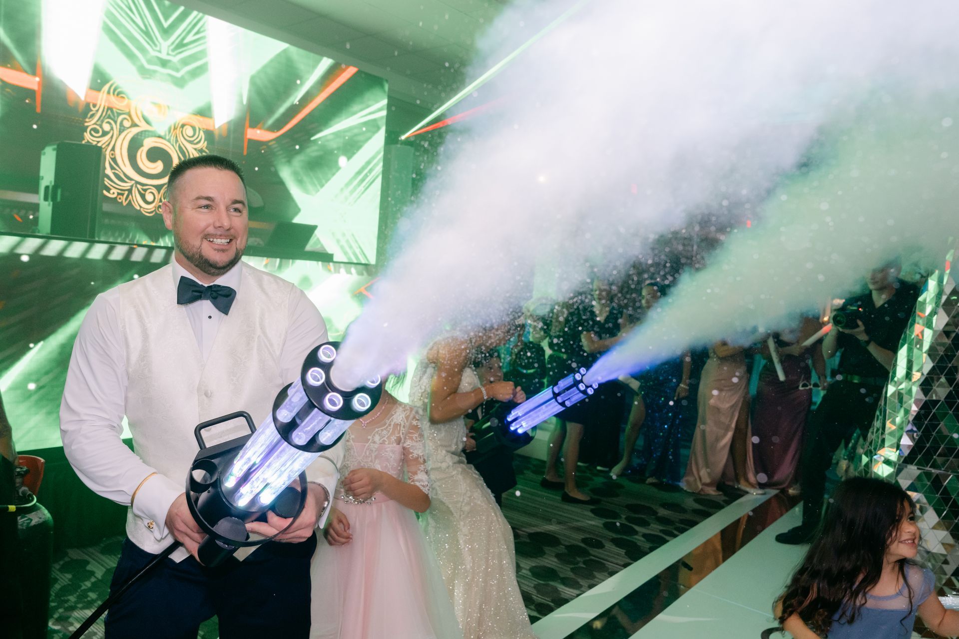 Bride and groom celebrating at a wedding reception with fireworks and a DJ in the background