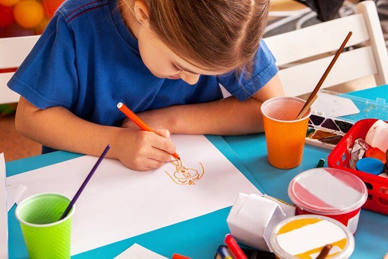 Child Drawing With Orange Marker — Child Care in Bowen, QLD