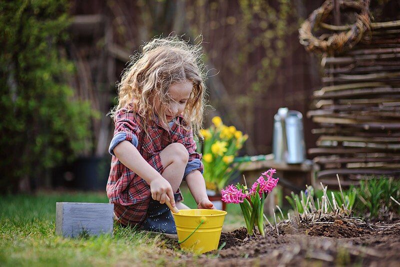 Kid Planting Hyacinth Flowers — Child Care in Bowen, QLD
