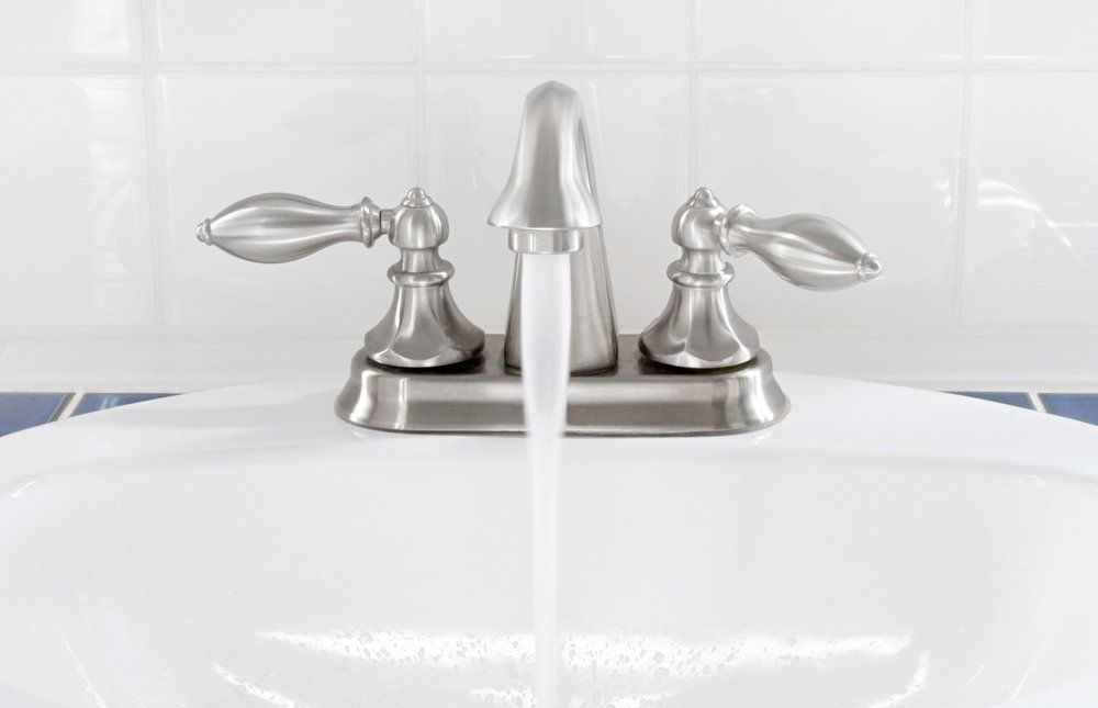 A bathroom sink with water running from the faucet.
