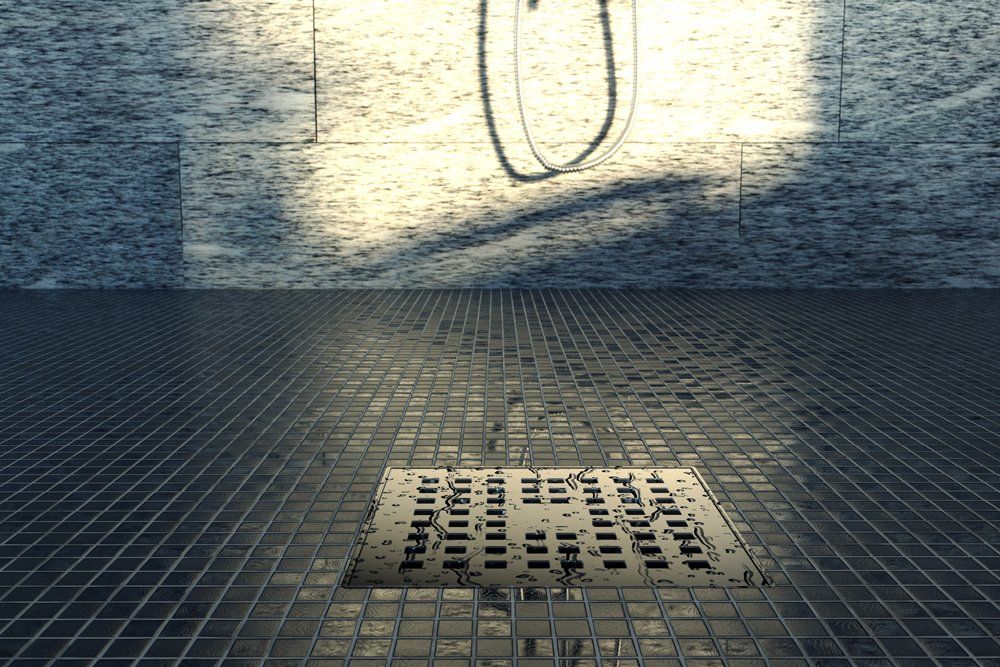 A manhole cover is sitting on a tiled floor next to a brick wall.