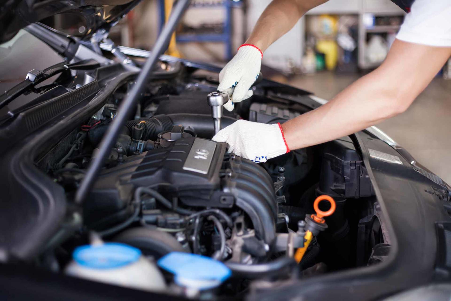 Hands of car mechanic in auto repair service.