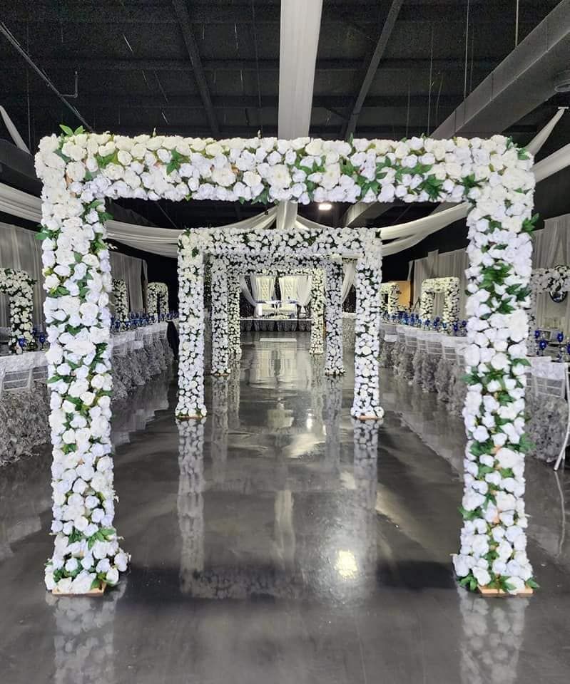 A large room with tables and chairs decorated with white flowers and greenery.