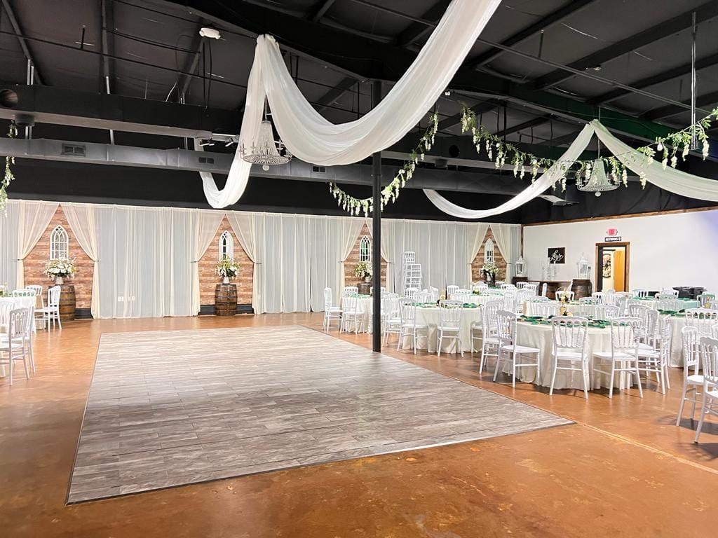 A large room with tables and chairs and a dance floor.