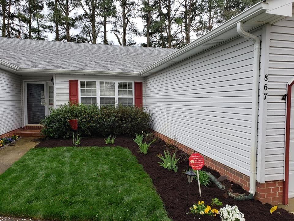 Exterior view of a white-sided house with a lawn and flower bed, address 867.
