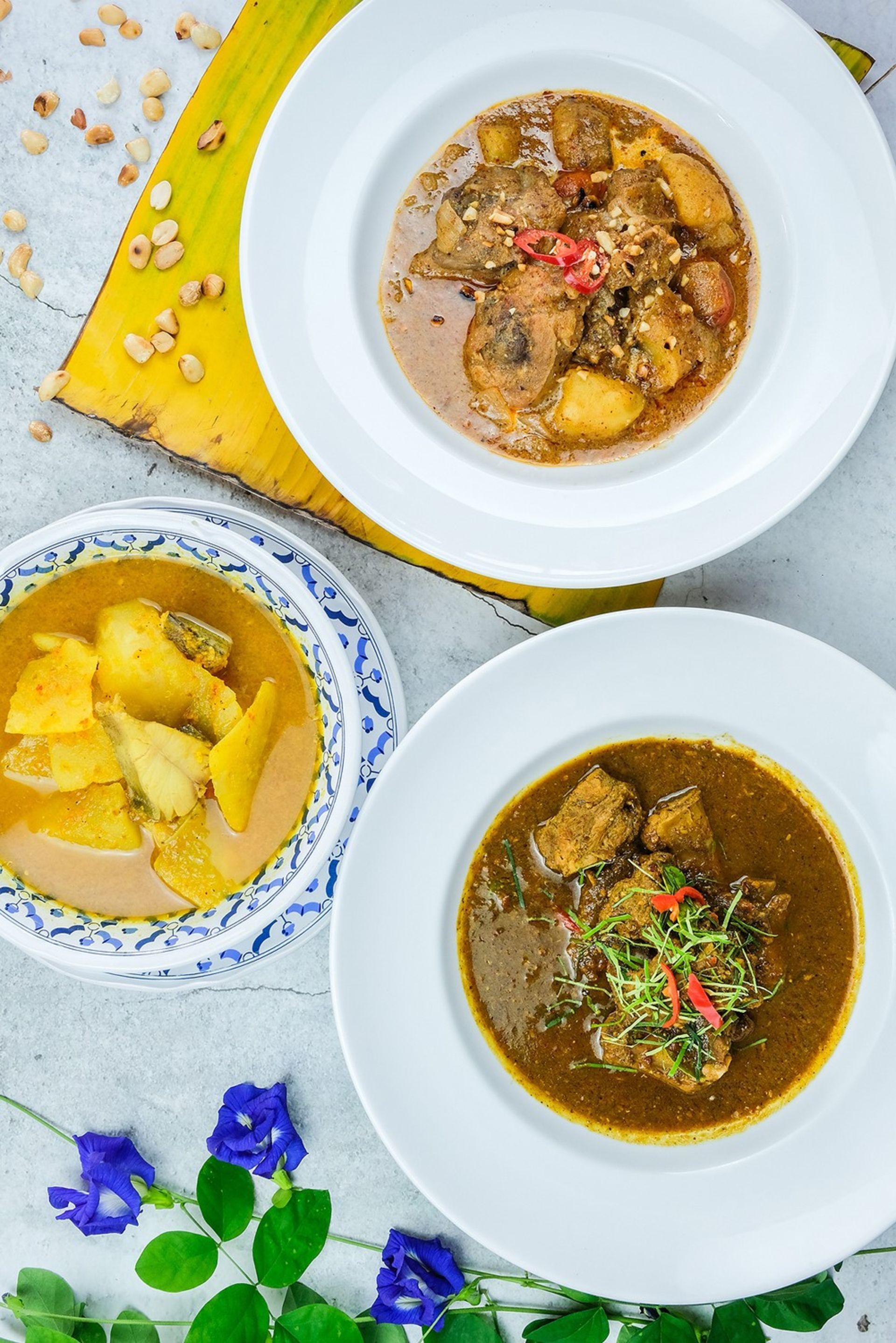 Thai food dishes on white and blue plates.