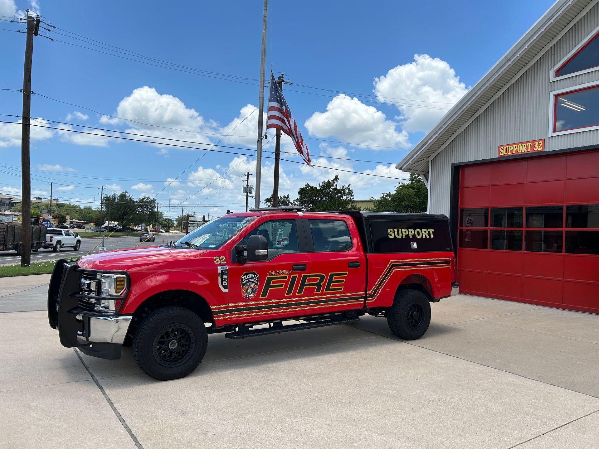 A red fire truck labeled as Support 32 is parked in front of a fire station.
