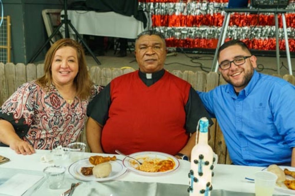 Three people sitting at a table during a festive gathering.