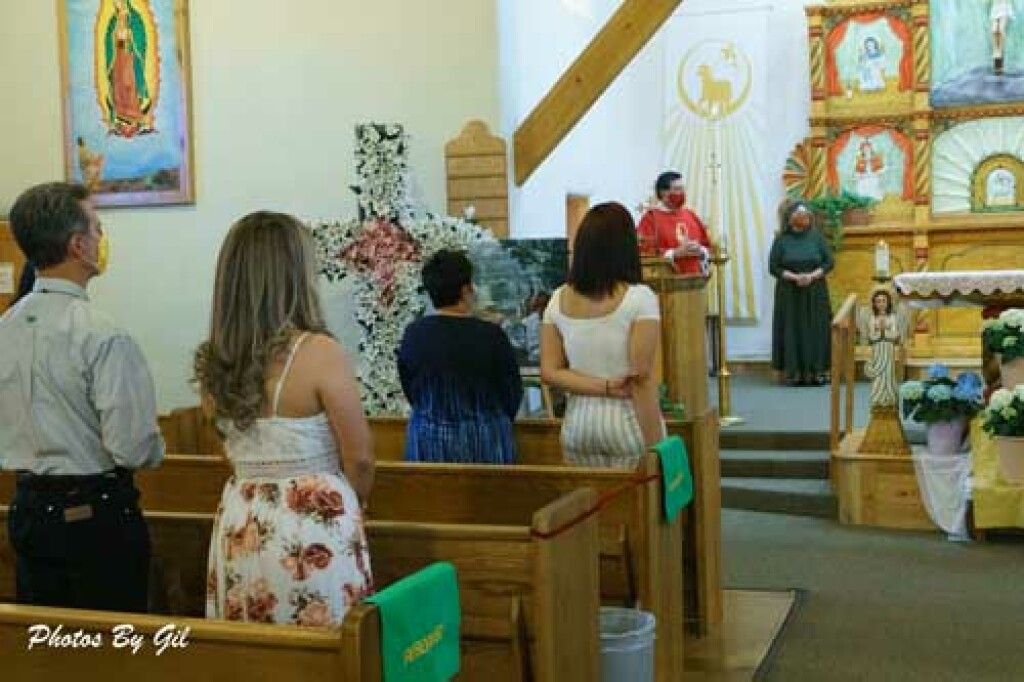 A group of people in a church faces the altar during a service. 