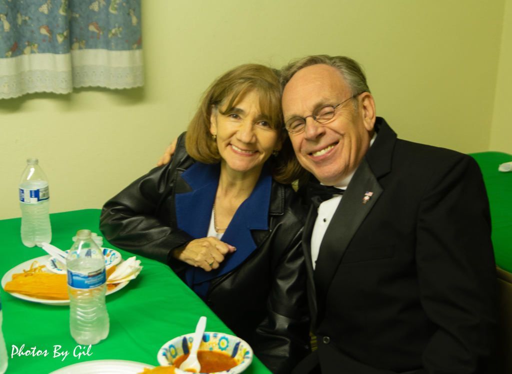 A smiling couple sits at a table.