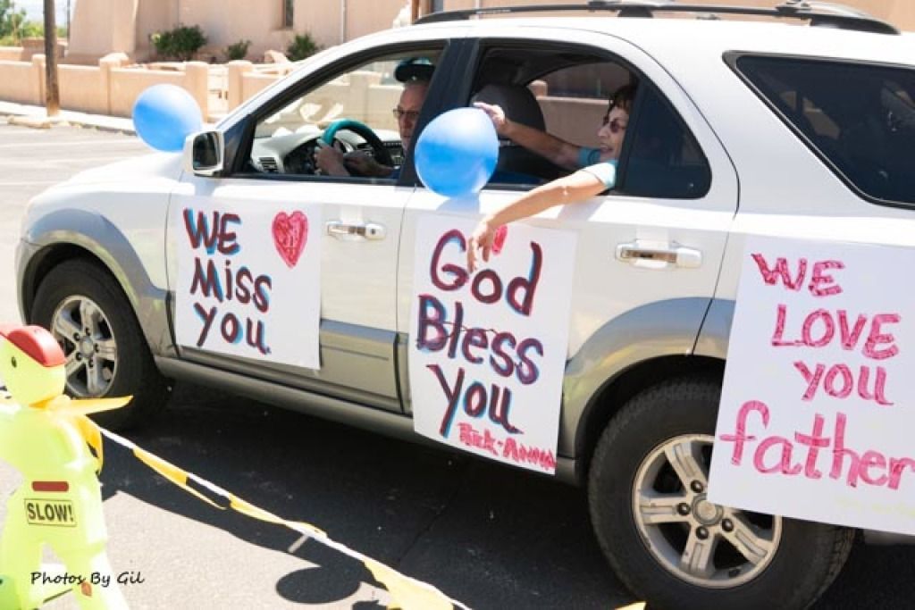 A silver SUV decorated with blue balloons and heartfelt signs.