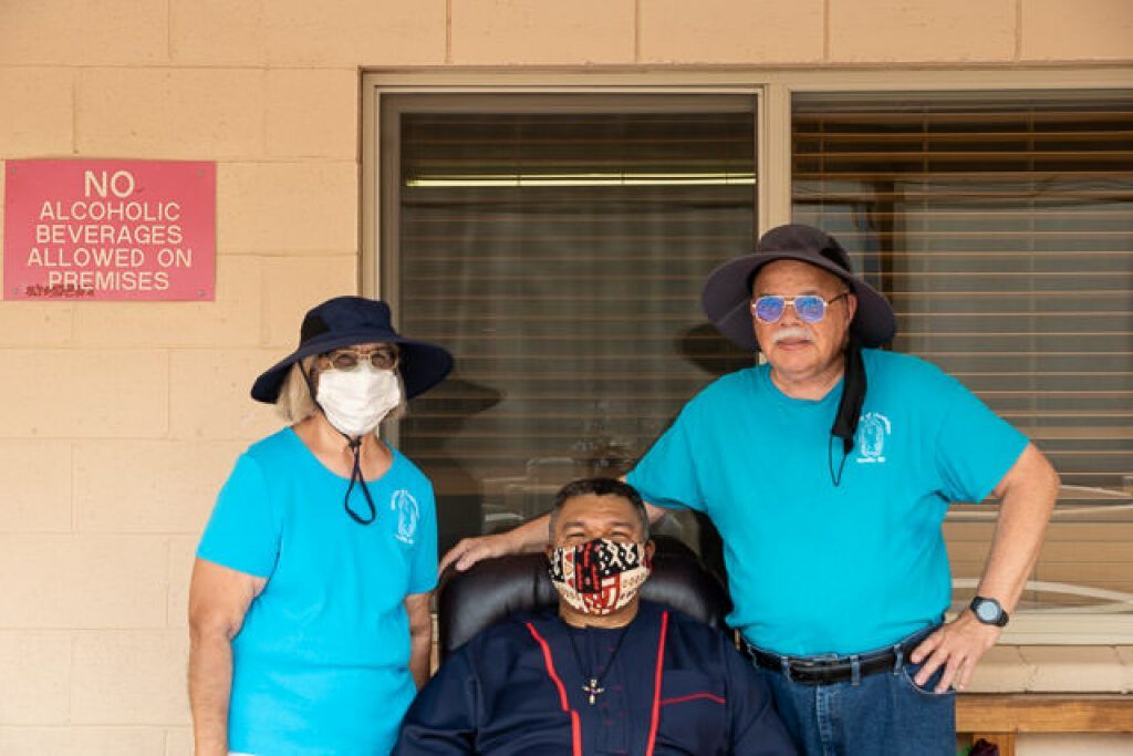 Three people are outside a building.