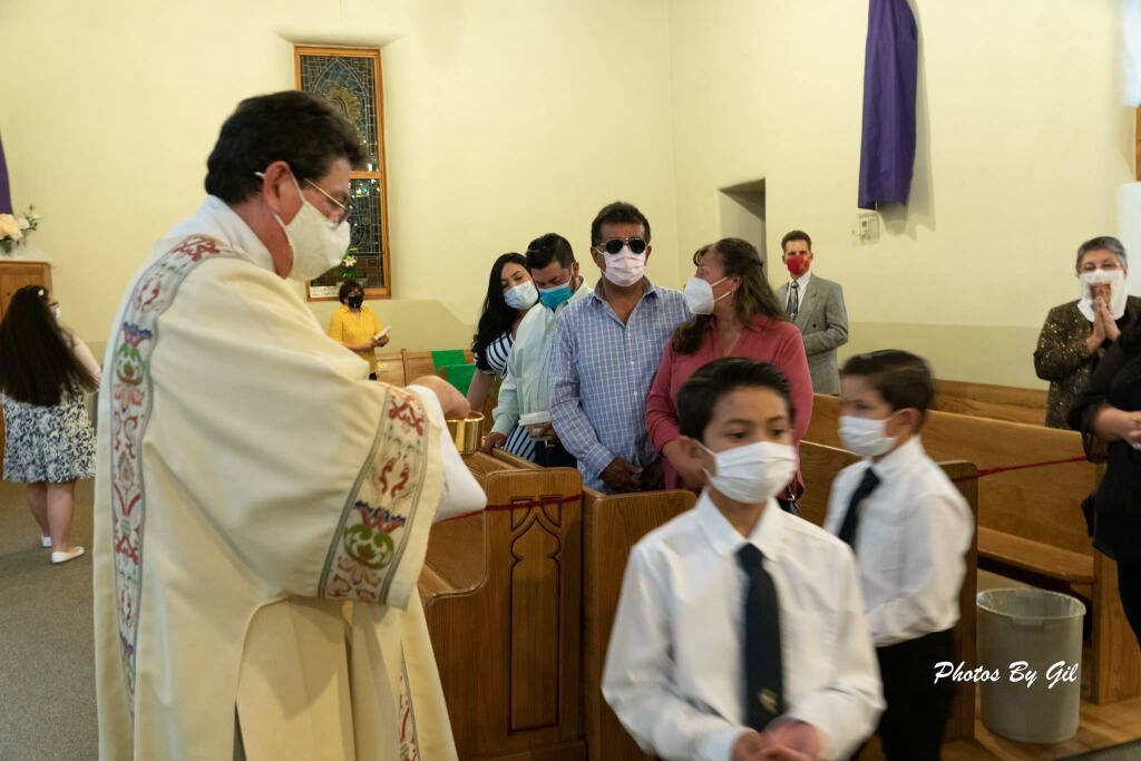 A masked priest in ceremonial robe stands in a church.
