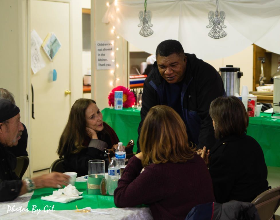 A friendly gathering at a table with five people chatting.